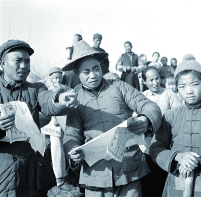 1950年,浙江省杭县临平区,土改工作队的工作人员(左)带领农民进行